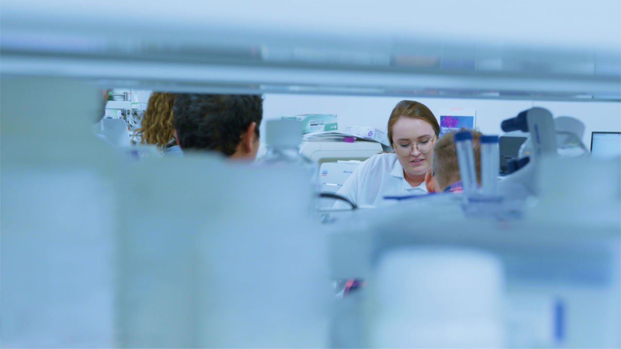 Woman in research laboratory talking to group of people